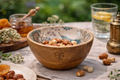 Wooden bowl with bird design with nuts on a table with a blurred natural background